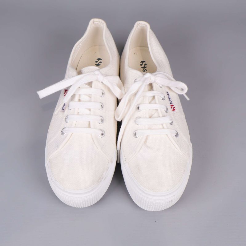 Sneakers sedd uppifrån med vita snören och logotyp