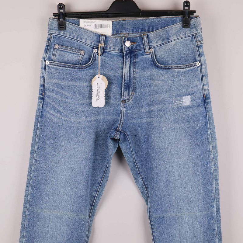 Närbild på jeansens framfickor och linning