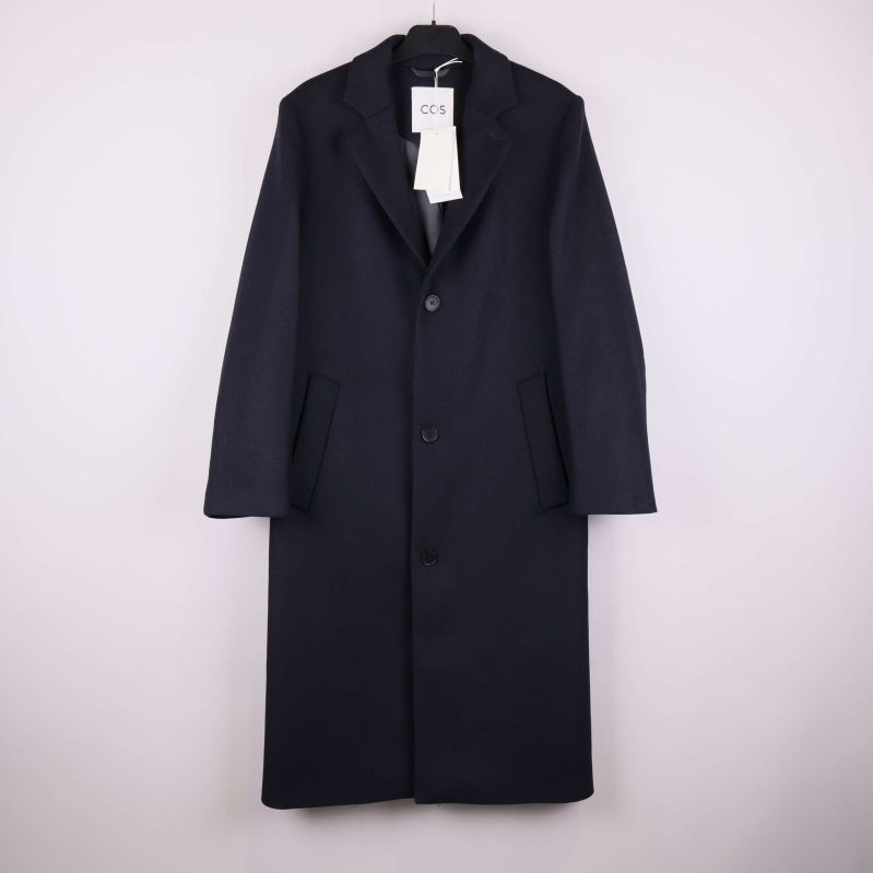 Lång svart rock med tre knappar framifrån på galge