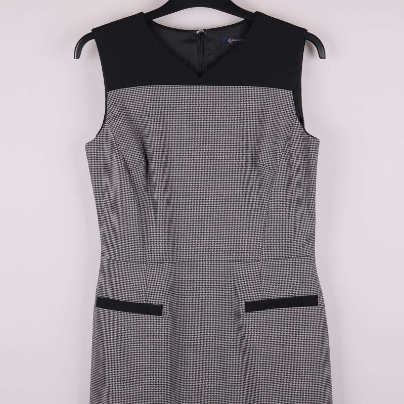 Närbild på överdelen med svarta detaljer och rutigt tyg