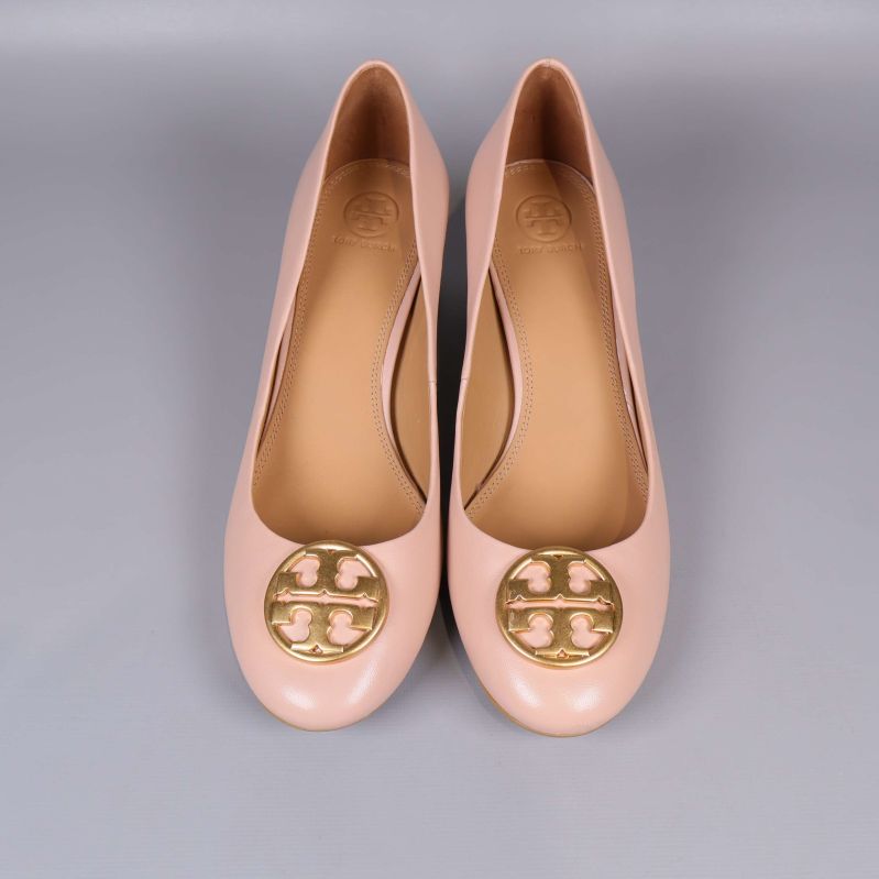 Pumps med dekorativ guldlogo sedd ovanifrån