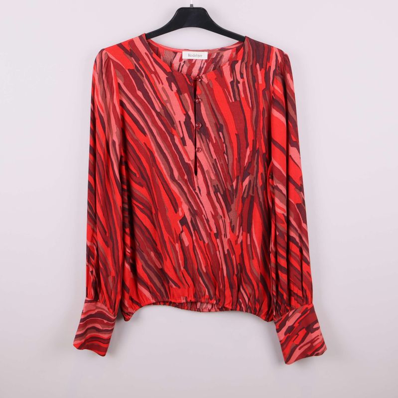 Röd mönstrad blus på galge, framtill