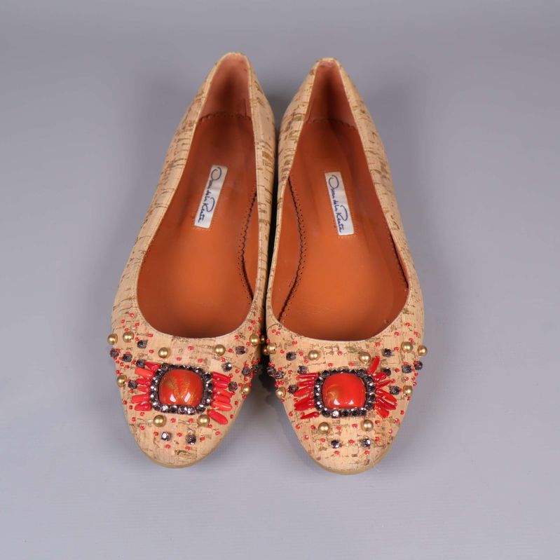Ballerinaskor med röda och guldiga detaljer sedd ovanifrån