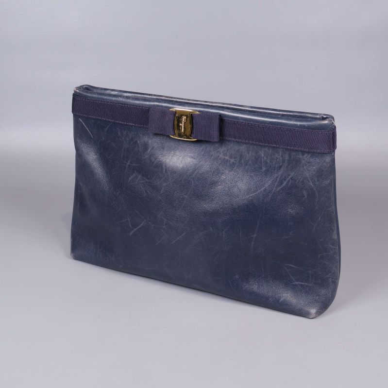 Blå axelväska stående med guldfärgat spänne