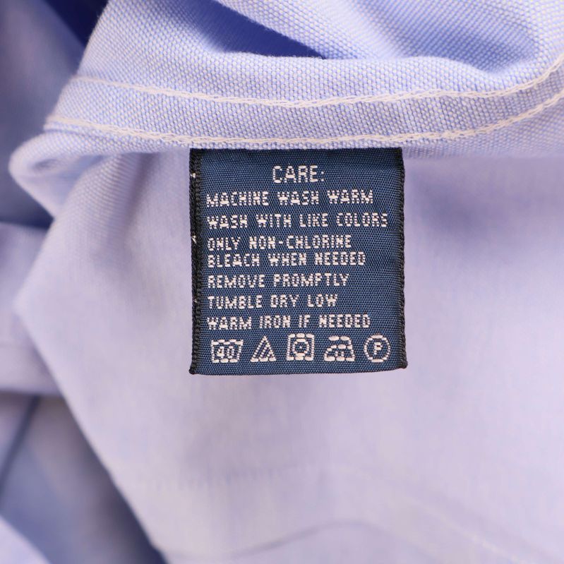 Tvättrådsetikett med skötselråd på insidan av skjortan