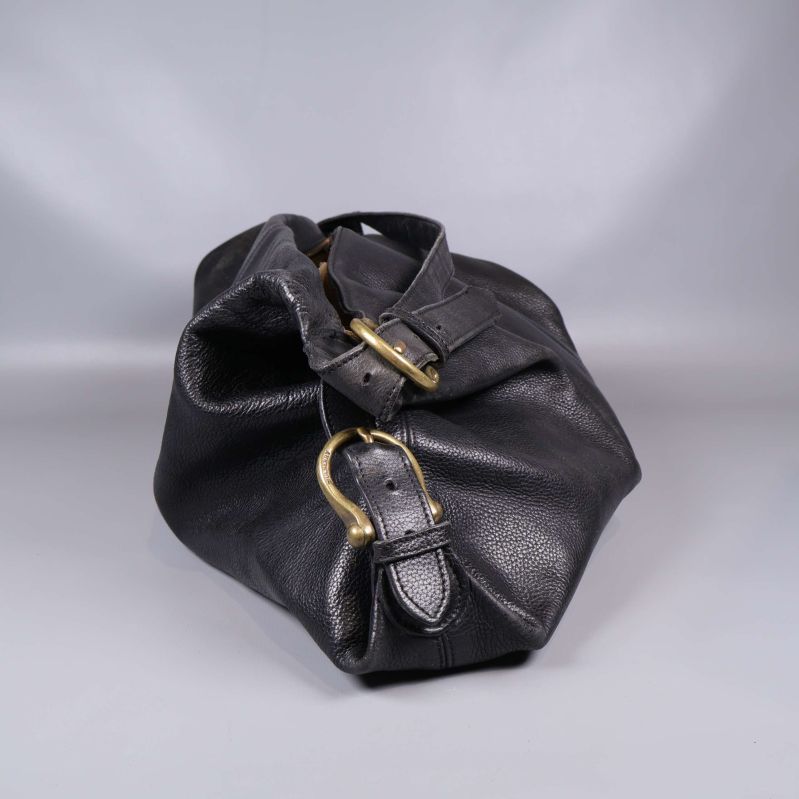 Sida av svart läderväska med justerbar rem