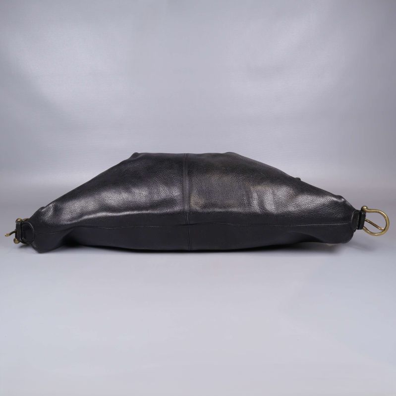 Svart läderväska fotograferad liggande med mässingsspännen