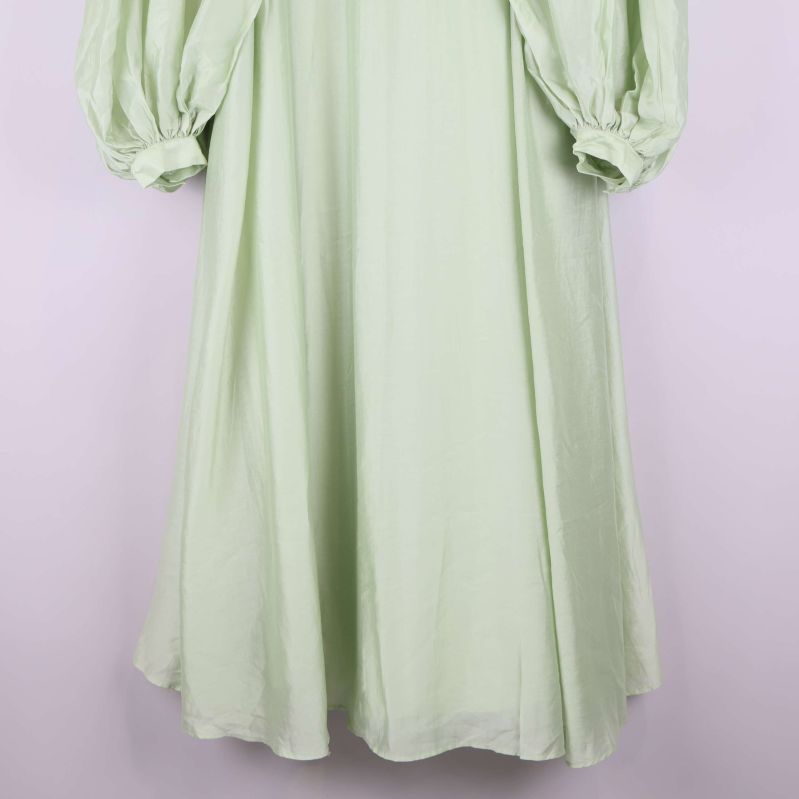 Nederdel av ljusgrön klänning med utsvängd fåll