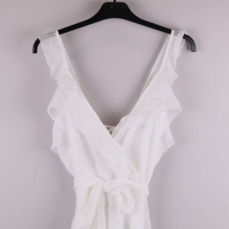 Närbild av klänningens axelband och volanger