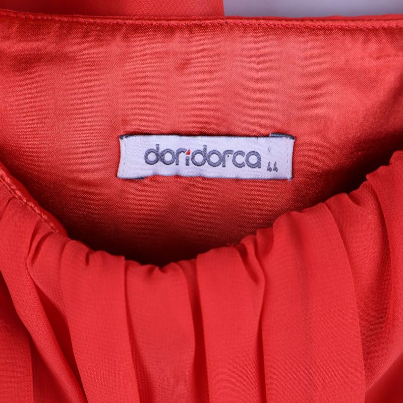 Närbild på doridorca-etikett i röd klänning