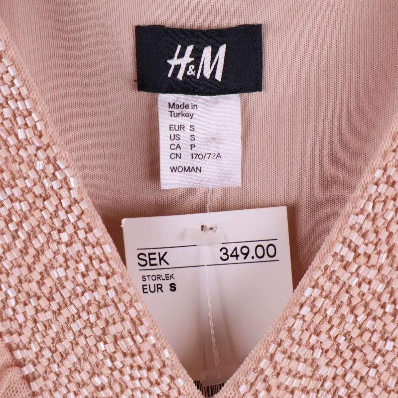 Närbild på H&M-etikett och prislapp storlek S