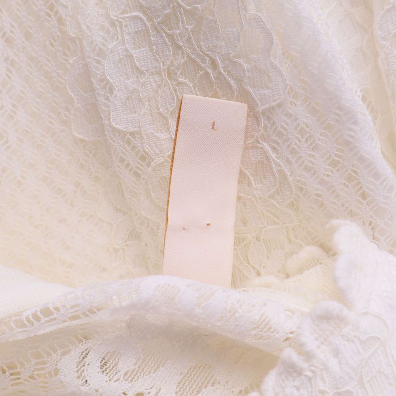 Storlekslapp med bokstaven L i vit spetsklänning