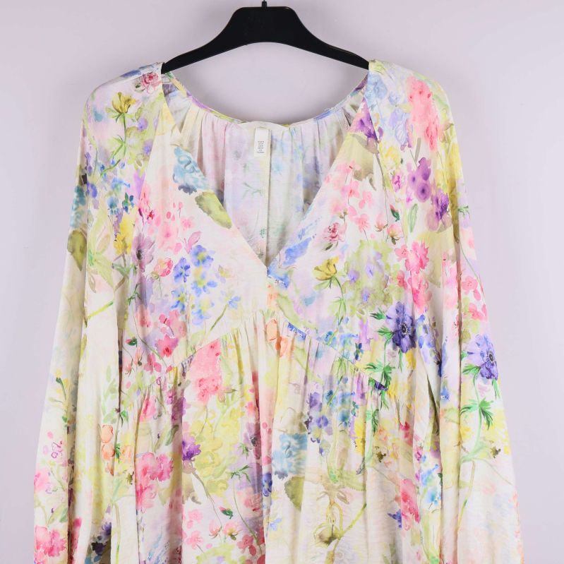 Närbild överdel av klänning med v-ringning och blommönster