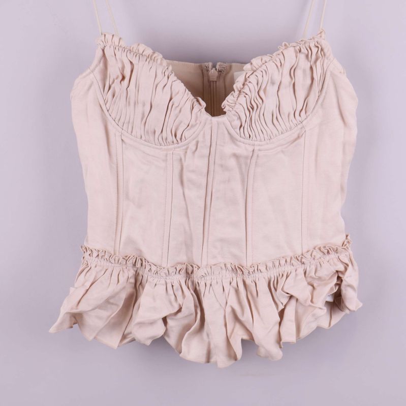 Framsidan av bustiern med tydliga volang- och rynkdetaljer