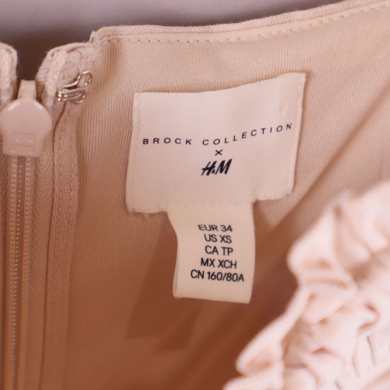 Närbild på etikett med Brock Collection x H&M och storleksangivelse