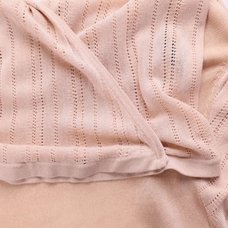 Närbild på strukturerad stickning och tyg vid knuten