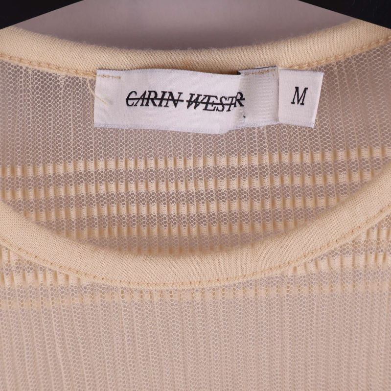 Närbild på etikett med Carin Wester och storlek M