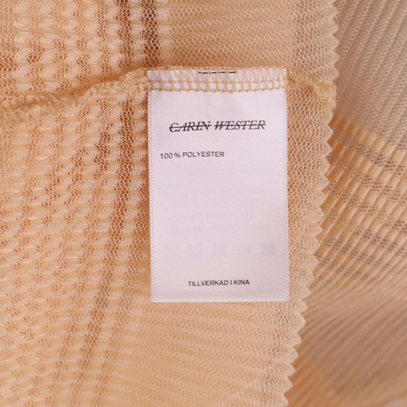 Materialetikett med 100% polyester och Carin Wester