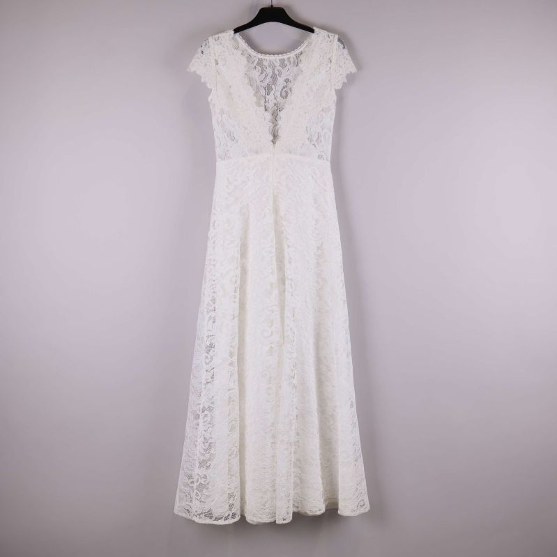 Vit lång spetsklänning upphängd på galge, helbild bakifrån