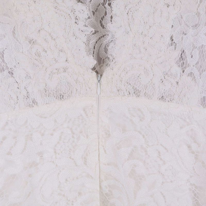 Närbild på dragkedjan bak på vit spetsklänning