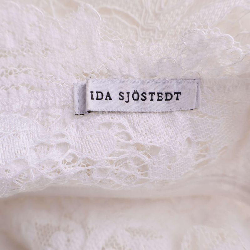 Ida Sjöstedt varumärkesetikett i vit spetsklänning