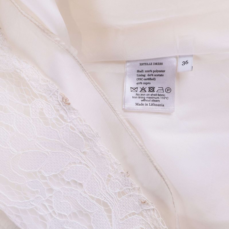 Tvättlapp med materialinfo i vit spetsklänning, storlek 36