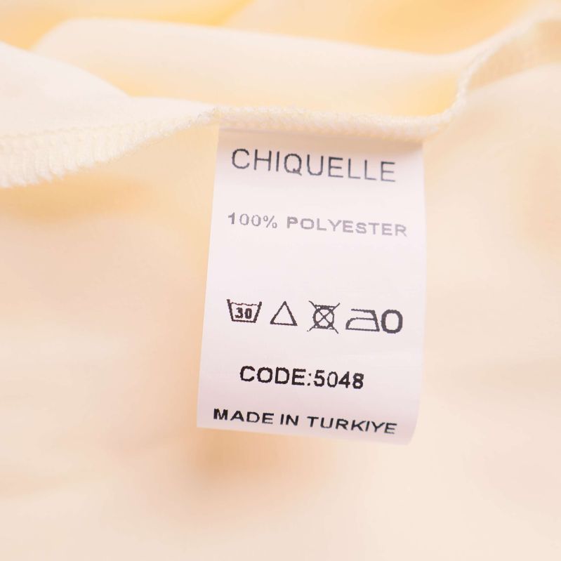 Materiallapp med texten 100% polyester från Chiquelle