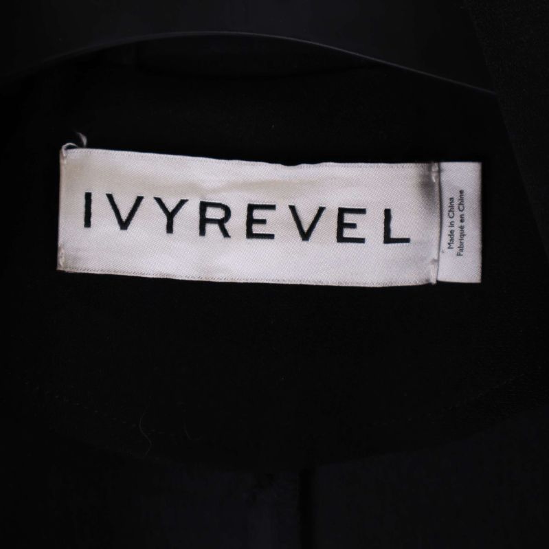 Närbild på IVYREVEL-loggan på kappans inneretikett