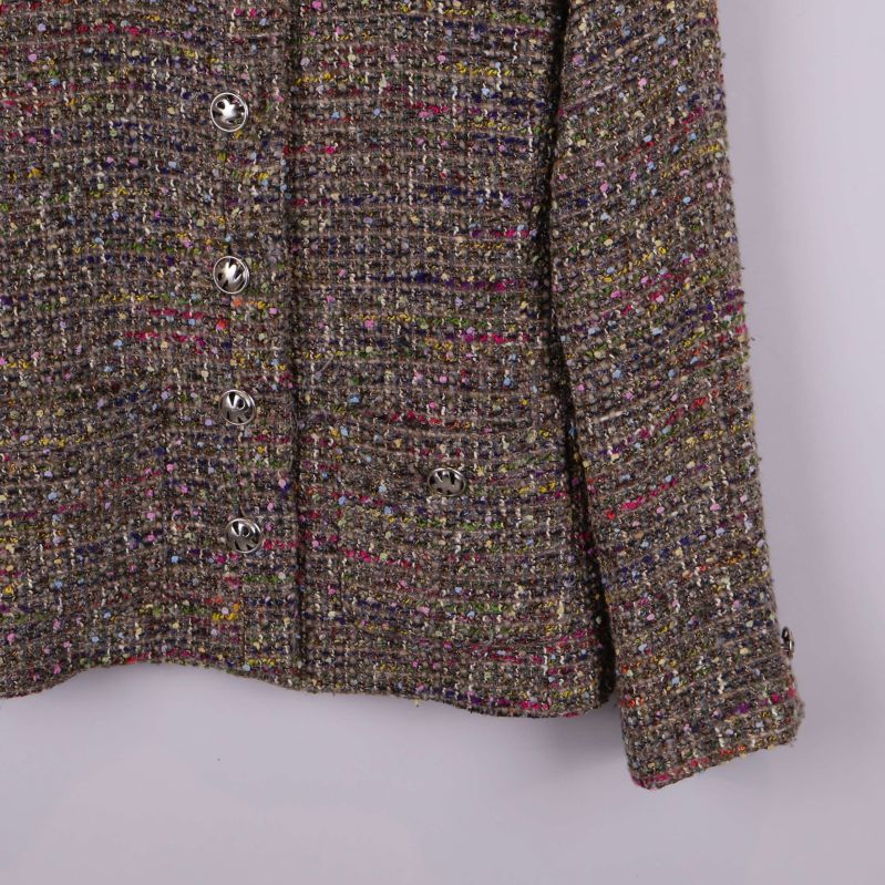 Närbild på soffärgad ärm och knappdetaljer framtill