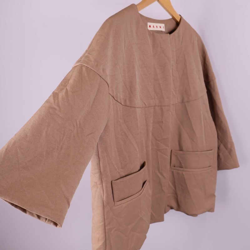 Beige jacka med vida ärmar och framfickor i sned vinkel