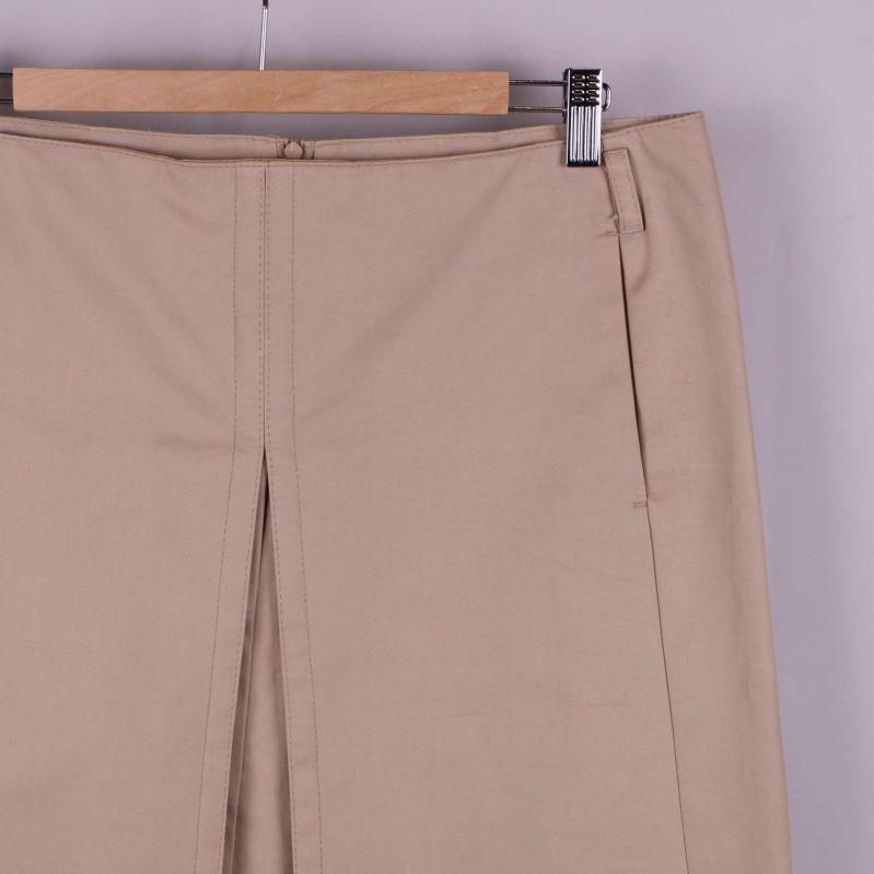 Övre del av beige kjol med veck och linning