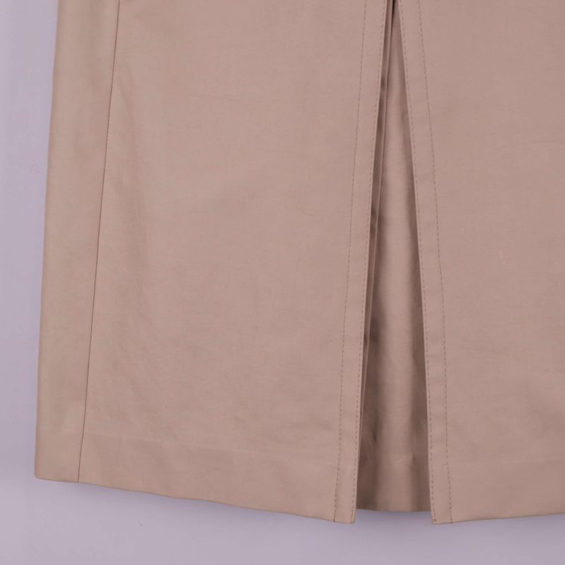 Nedre del av beige kjol med slits, liten fläck