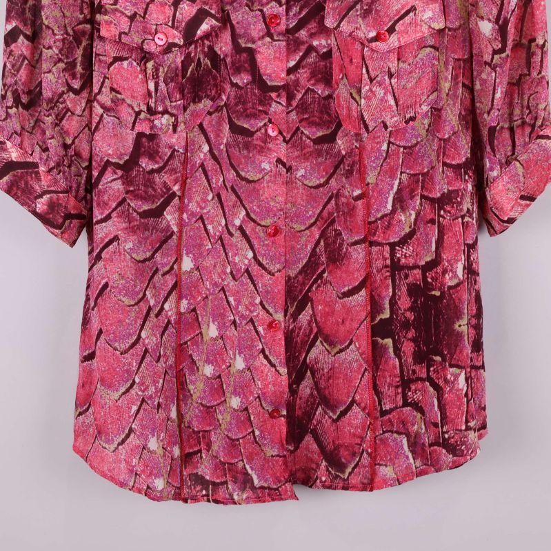 Närbild på blusens nedre del och mönster i rosa toner