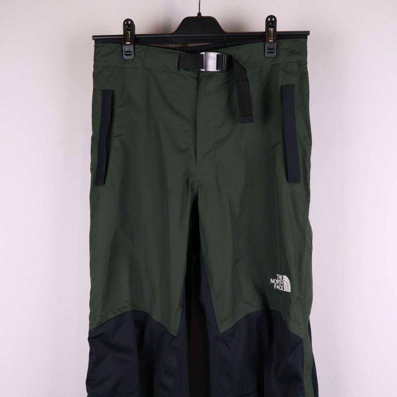 Övre delen av gröna byxor med dragkedjefickor och bälte