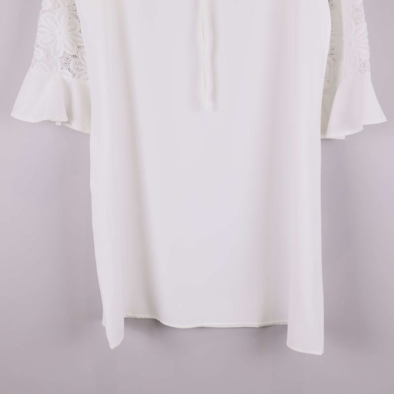 Nederkant av vit klänning med fallande tyg