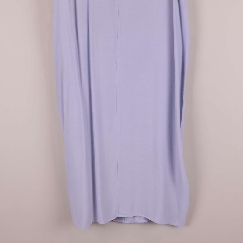 Nederdel av ljuslila klänning mot ljus bakgrund