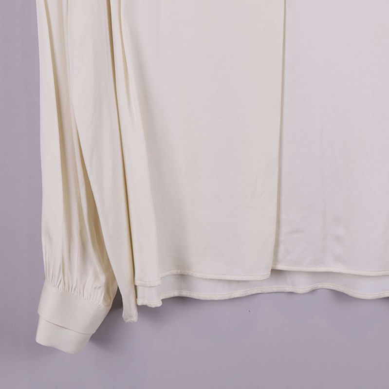 Närbild på blusens nederkant med dubbelt lager tyg