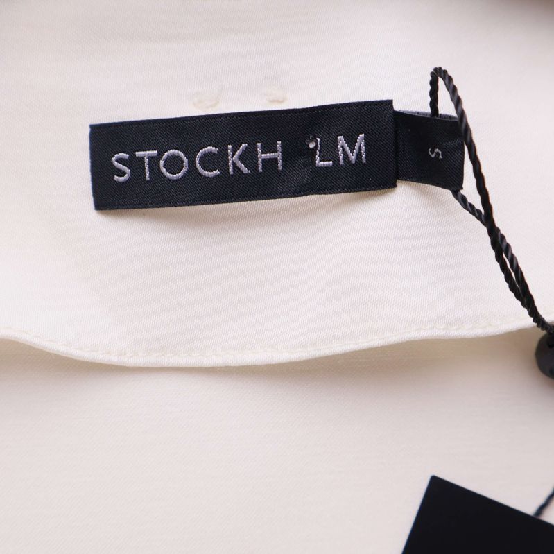 Närbild på Stockh lm-märke i nacken på blus