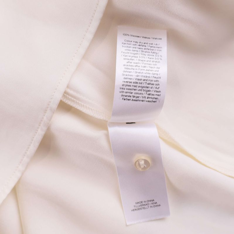 Tvättrådstag inuti blusen med söm och extra knapp