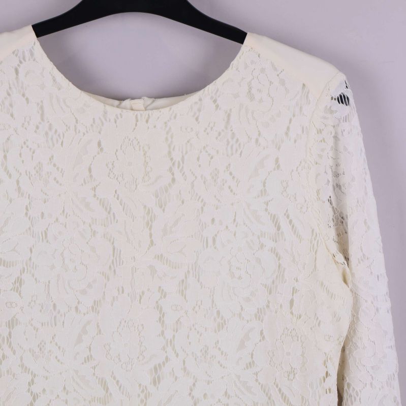 Övre del av blus med spets och axeldetaljer i fokus