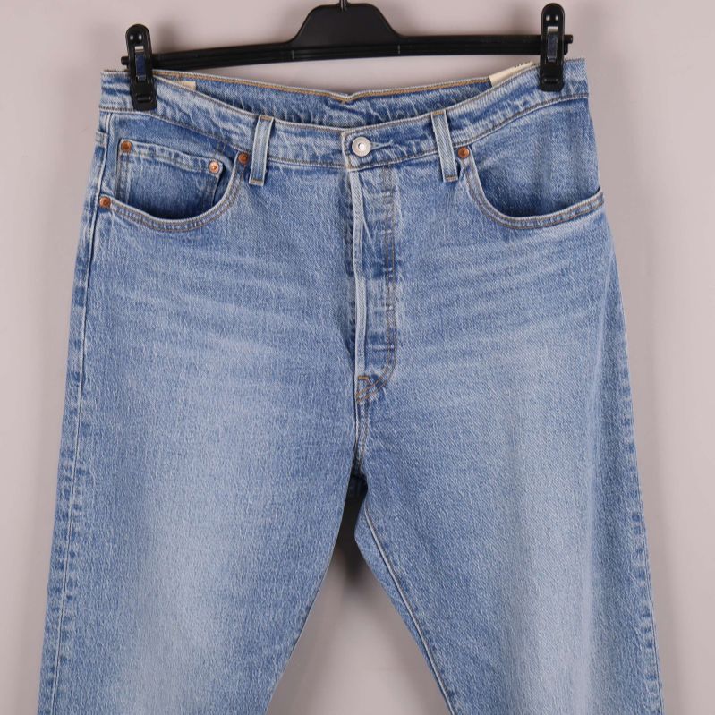 Närbild på midjan och framfickor av blå jeans