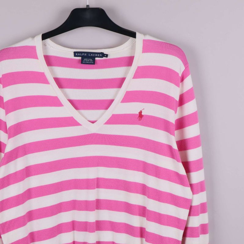 Närbild på bröstet med broderad logotyp på randig tröja