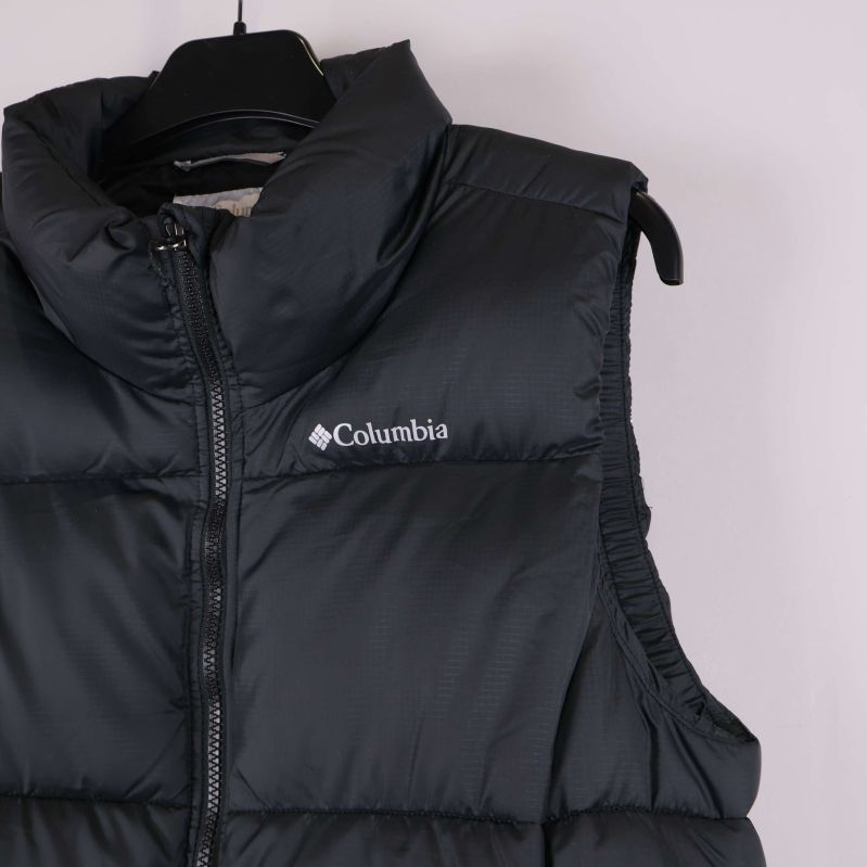 Närbild av övre del av väst med Columbia logotyp