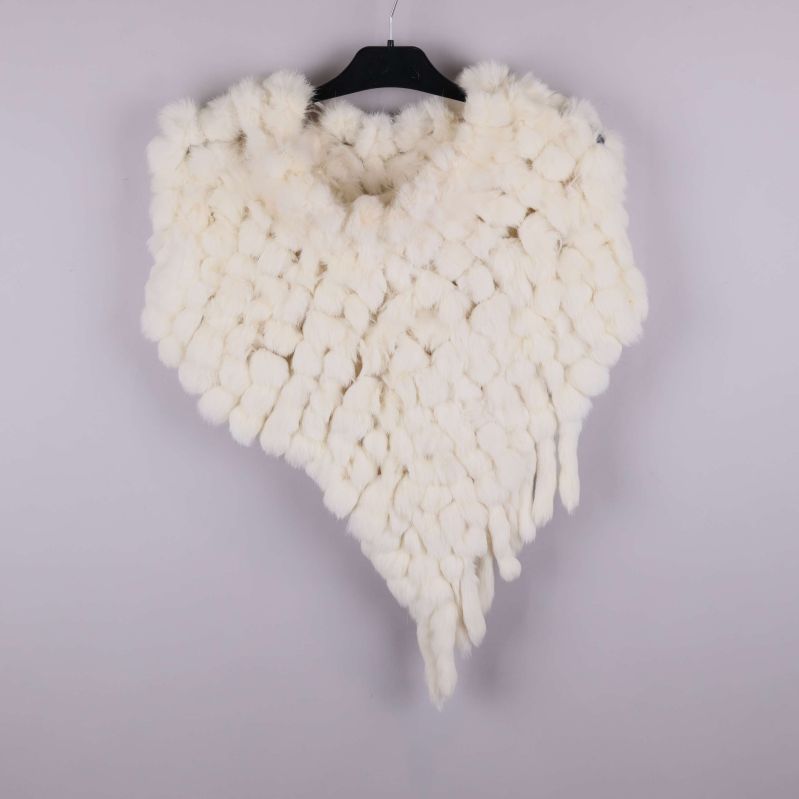 Poncho med tofsar i en enda ljus färg på galge