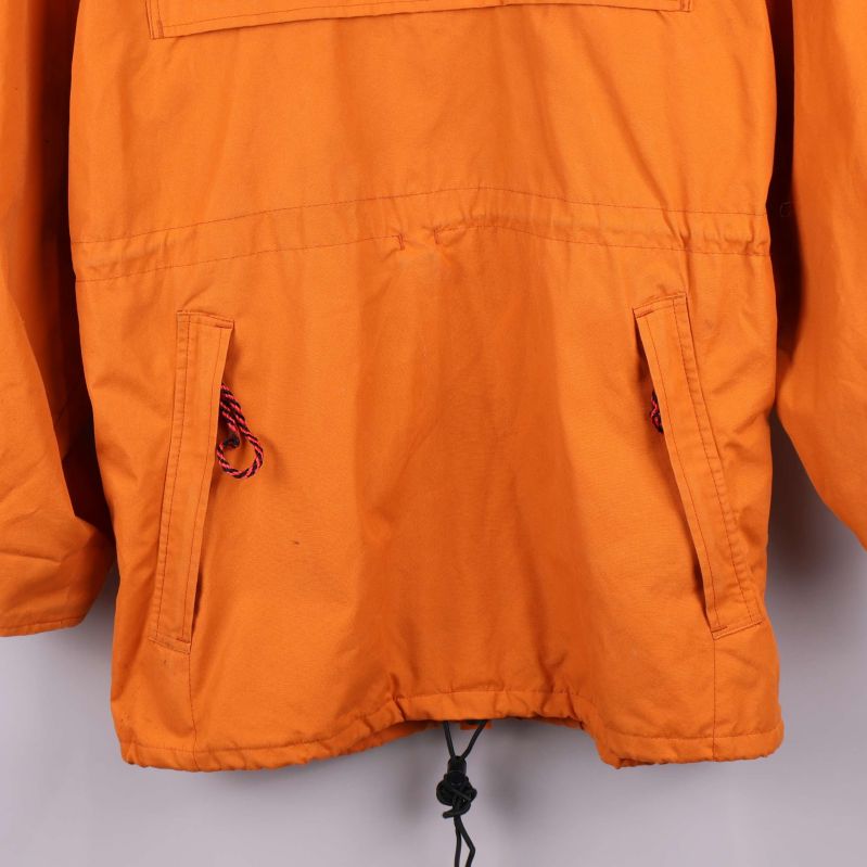 Fickor och nederkant på orange anorak med dragsko
