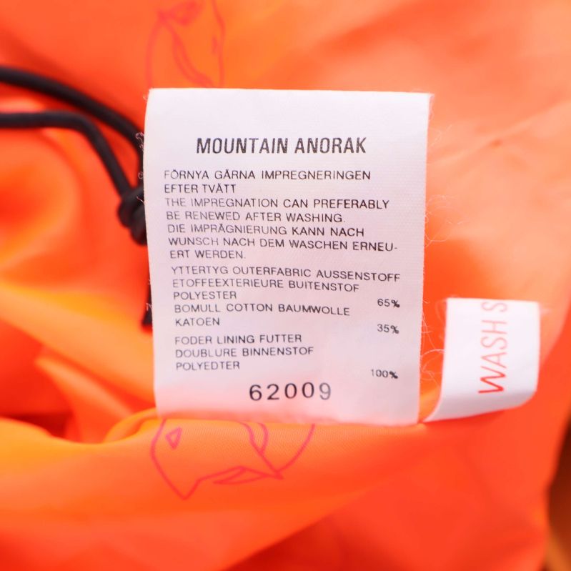 Materiallapp i orange anorak visar bomull och polyester