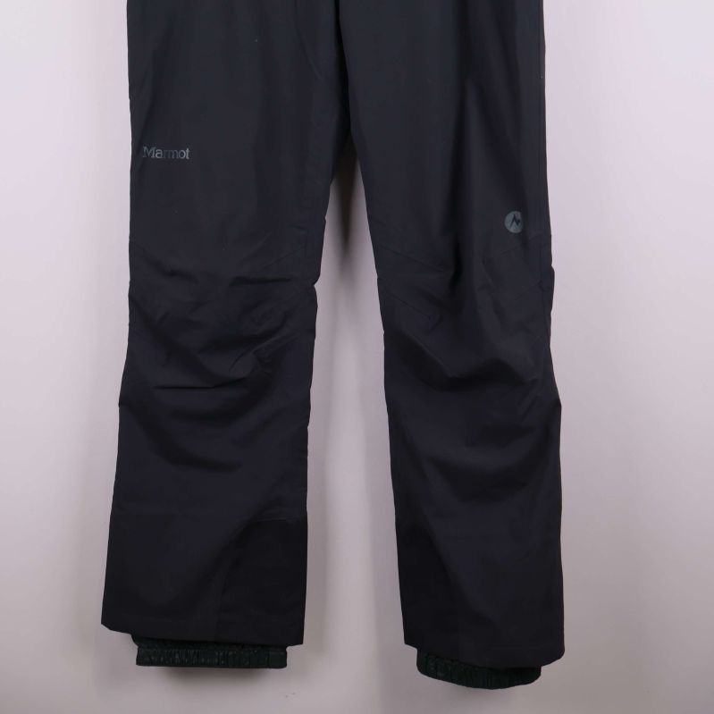 Nedre delen av svarta skidbyxor med förstärkta benslut