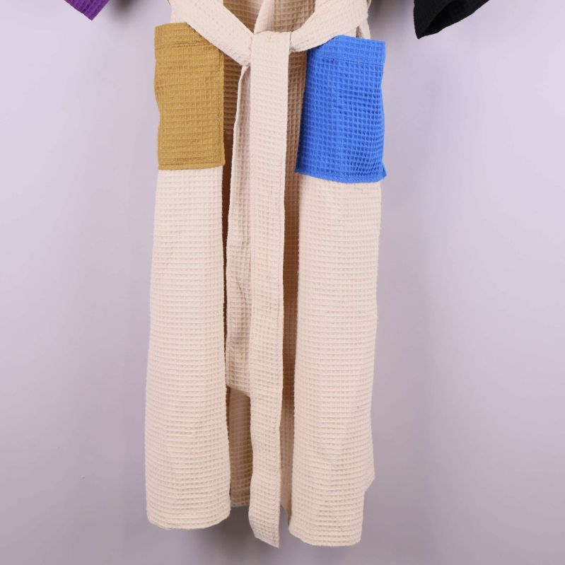 Detalj på midja och fickor i blått och brunt tyg