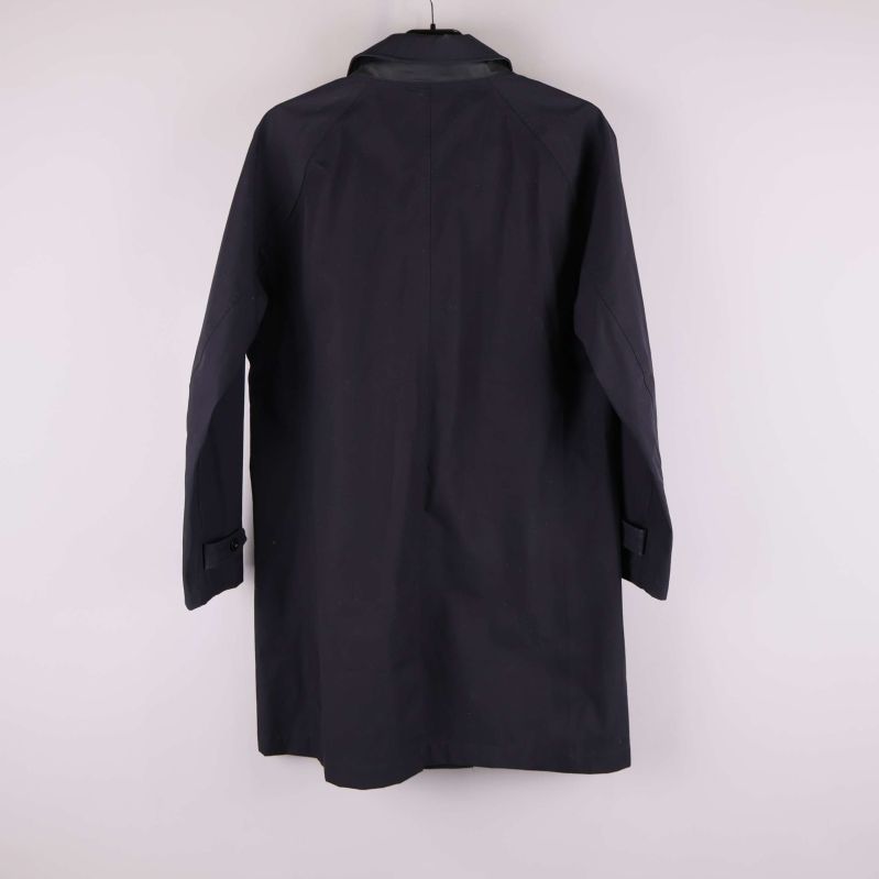 Baksida av lång mörk trenchcoat med enkel ryggsöm