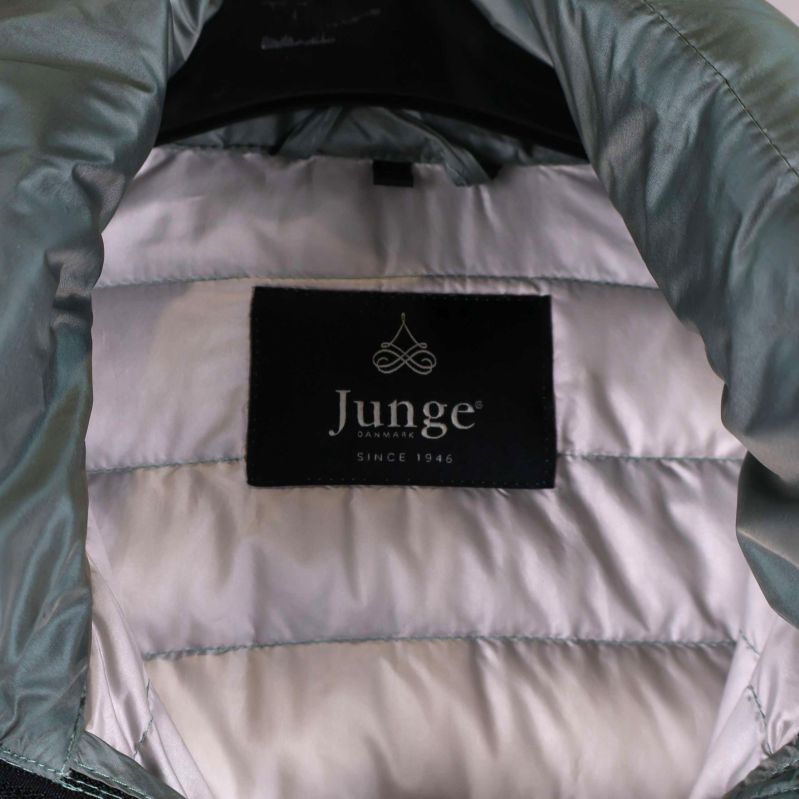 Inneretikett med Junge logotyp på ljus jacka